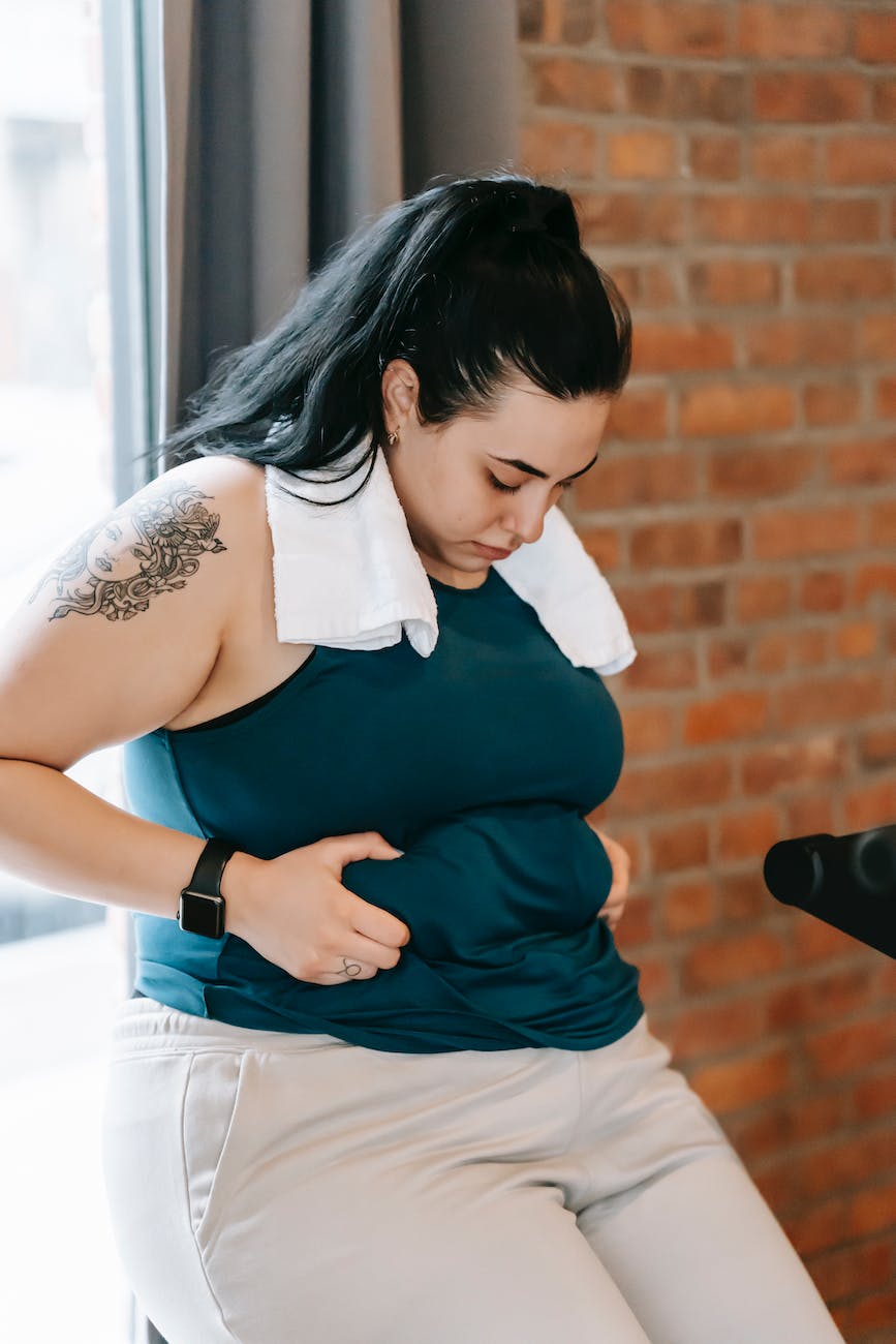 plus size woman holding fat fold on belly